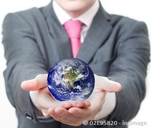 Man in a grey suit holding world globe in both hands