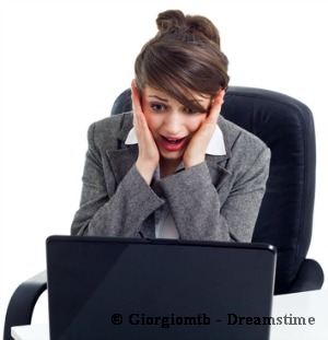 Shocked business woman in front of laptop